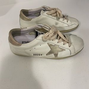 White sneakers with gold star.